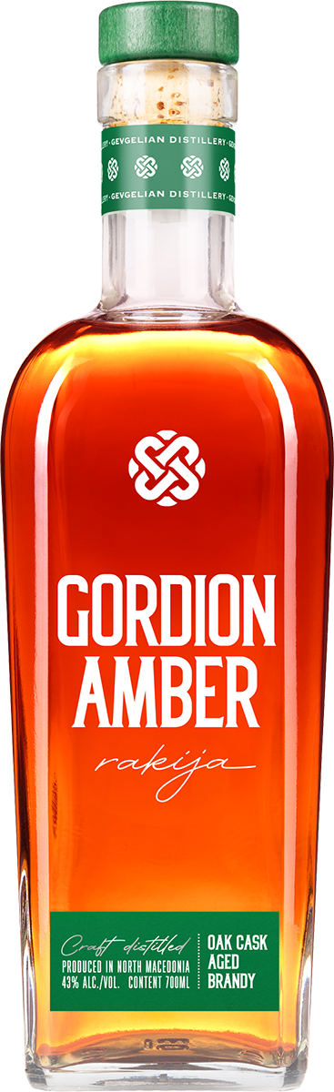 Шише бренд Gordion Amber ракија со јасно портокалово-амбер боја, зелена капачка и етикета со информации за производот.